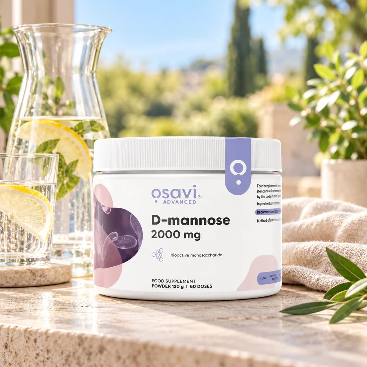 D-manoză Osavi, pudră 120 g — cutie lângă o carafă cu apă și lămâie